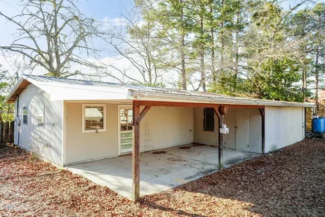 a view of a patio with table and chairs and a large tree