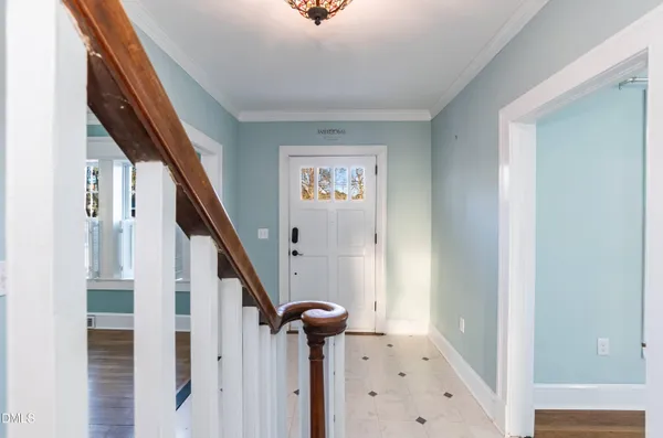 an empty room with wooden floor chandelier fan and windows