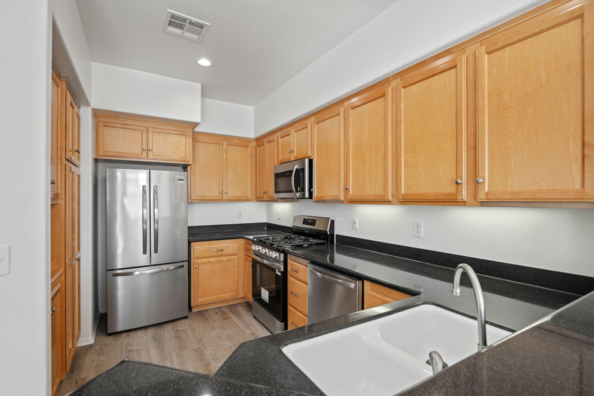 541 Sweet Rain Place Goleta, CA 93117 - Photo 11 of 40 a kitchen with stainless steel appliances granite countertop a refrigerator a sink dishwasher stove with open cabinets