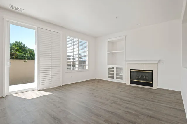 an empty room with windows and a fireplace