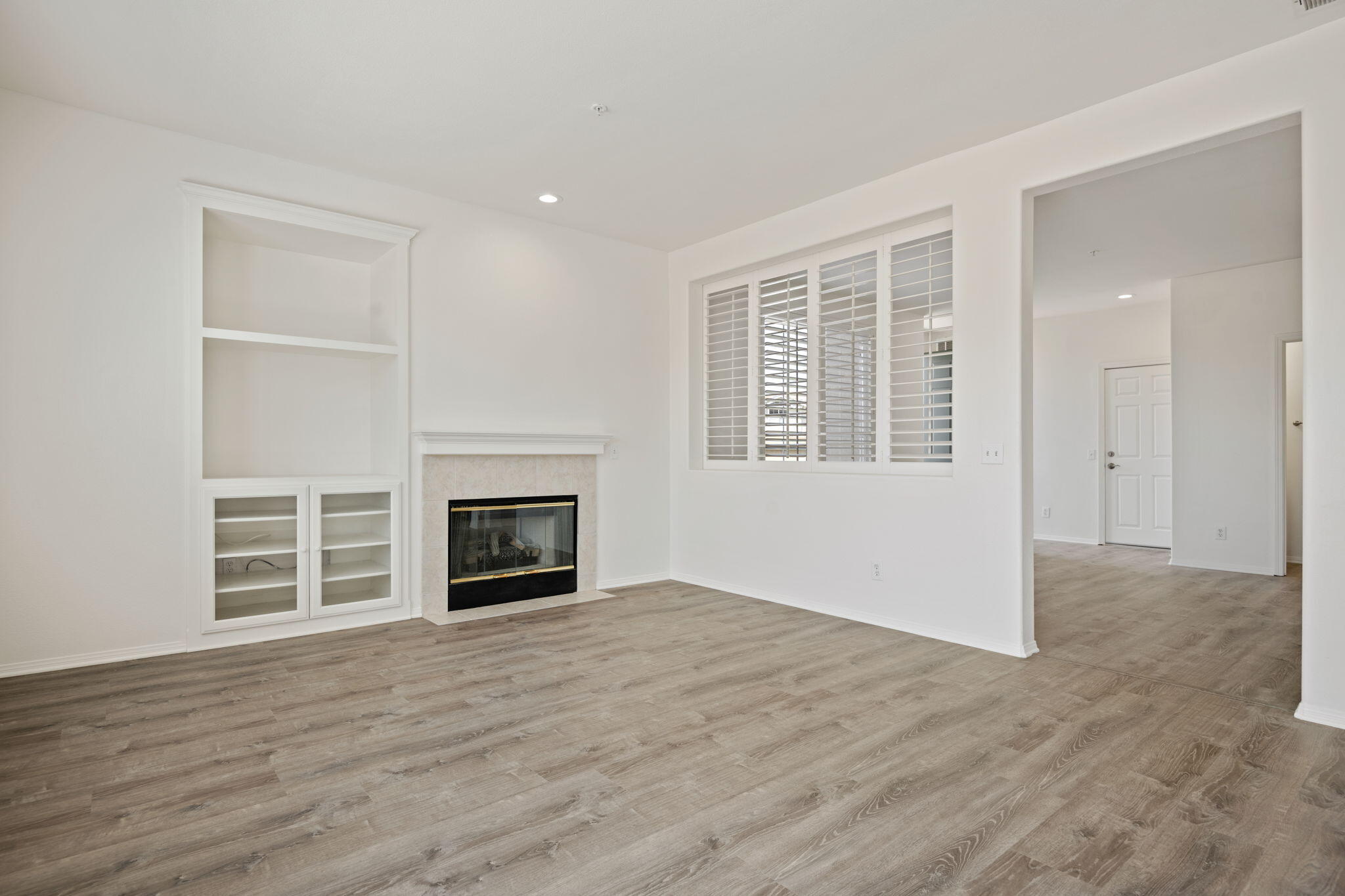 541 Sweet Rain Place Goleta, CA 93117 - Photo 7 of 40 an empty room with wooden floor fireplace and windows