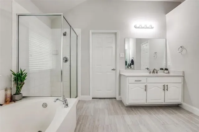 a bathroom with a tub sink and mirror