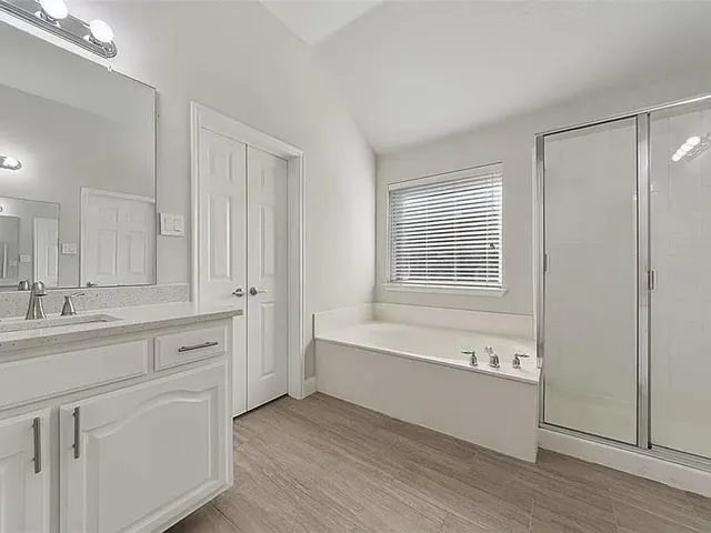 a bathroom with a tub sink and mirror