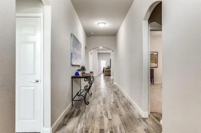 a view of a hallway with wooden floor and a living room