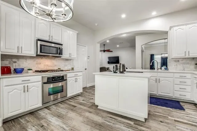 a kitchen with white cabinets stainless steel appliances and sink