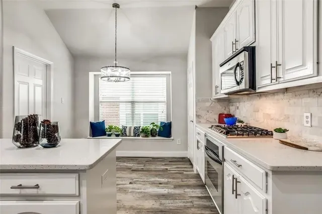 a kitchen with a stove a sink and a window
