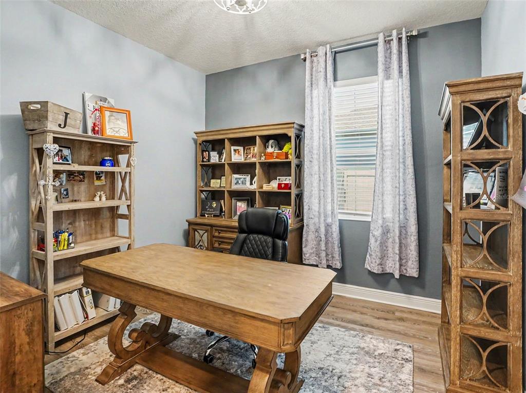 5270 Obsidian Gate Road Mount Dora, FL 32757 - Photo 19 of 50 a view of a workspace with furniture and a book shelf