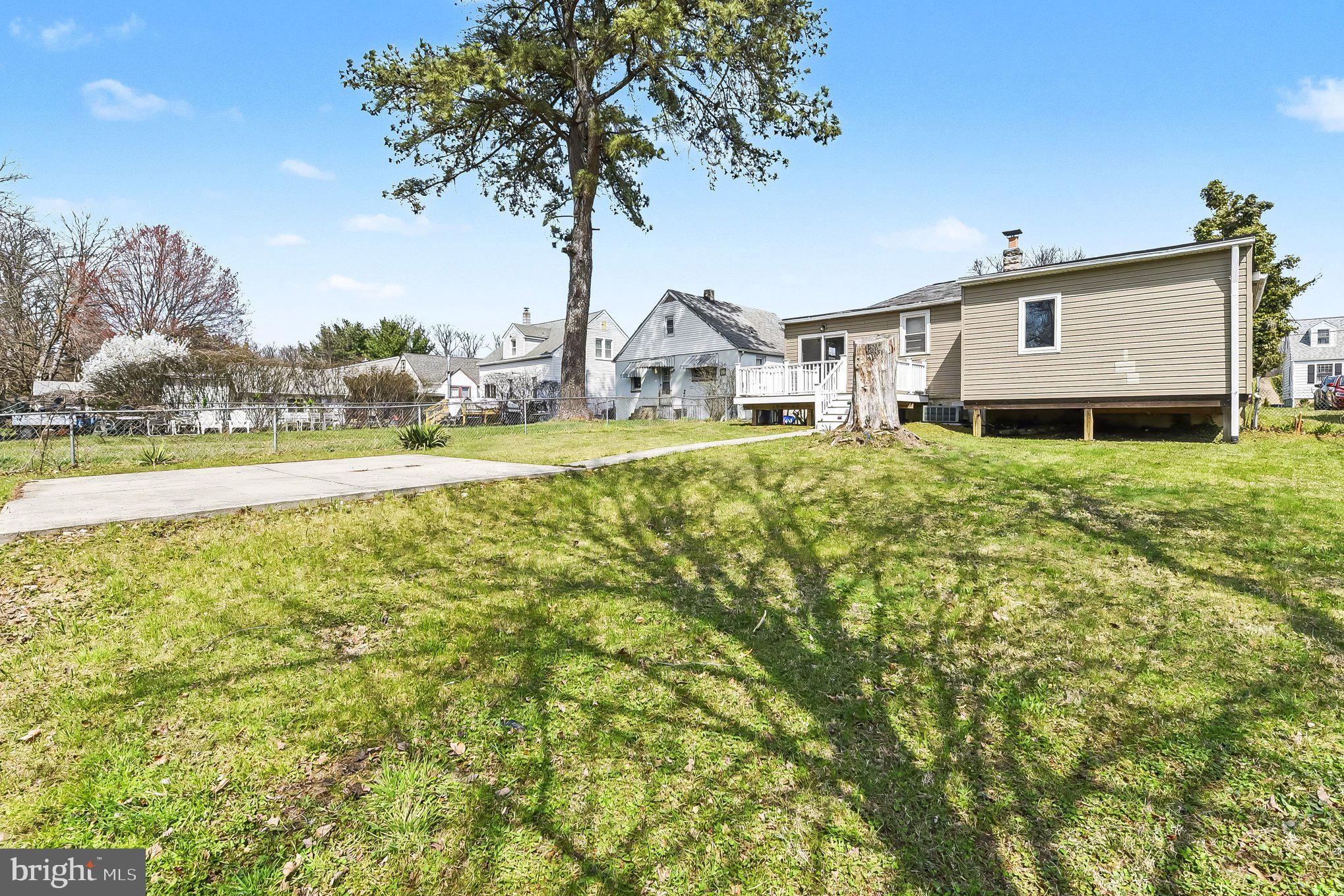 8716 Eddington Road Parkville, MD 21234 - Photo 16 of 27 a front view of a house with a garden and trees