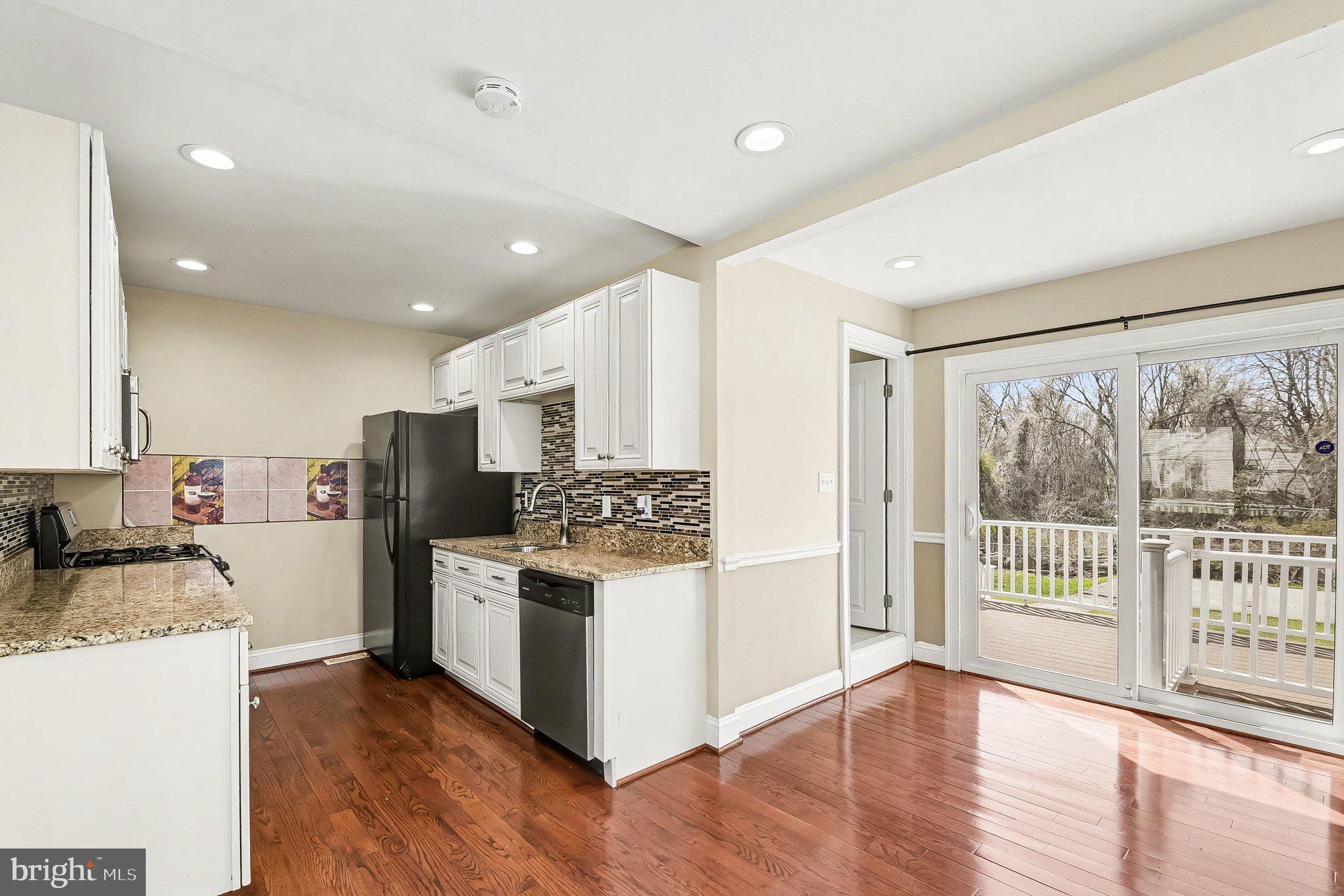 8716 Eddington Road Parkville, MD 21234 - Photo 21 of 27 a kitchen with a refrigerator a stove top oven a sink and a large window