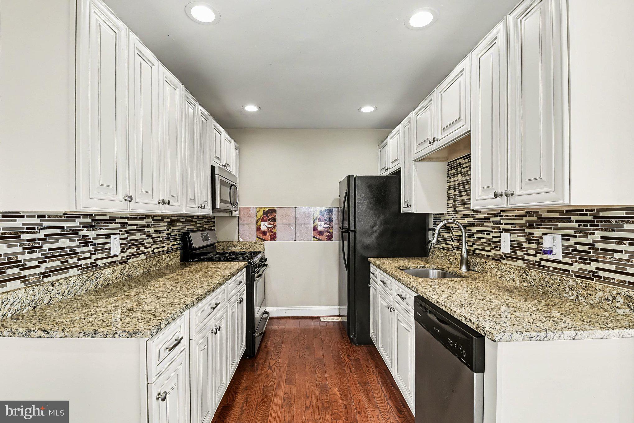 8716 Eddington Road Parkville, MD 21234 - Photo 22 of 27 a kitchen with stainless steel appliances granite countertop a sink stove and refrigerator