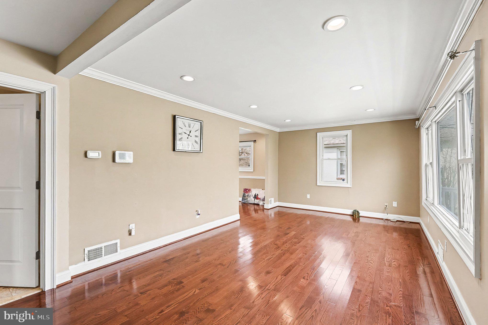 8716 Eddington Road Parkville, MD 21234 - Photo 4 of 27 an empty room with wooden floor and windows