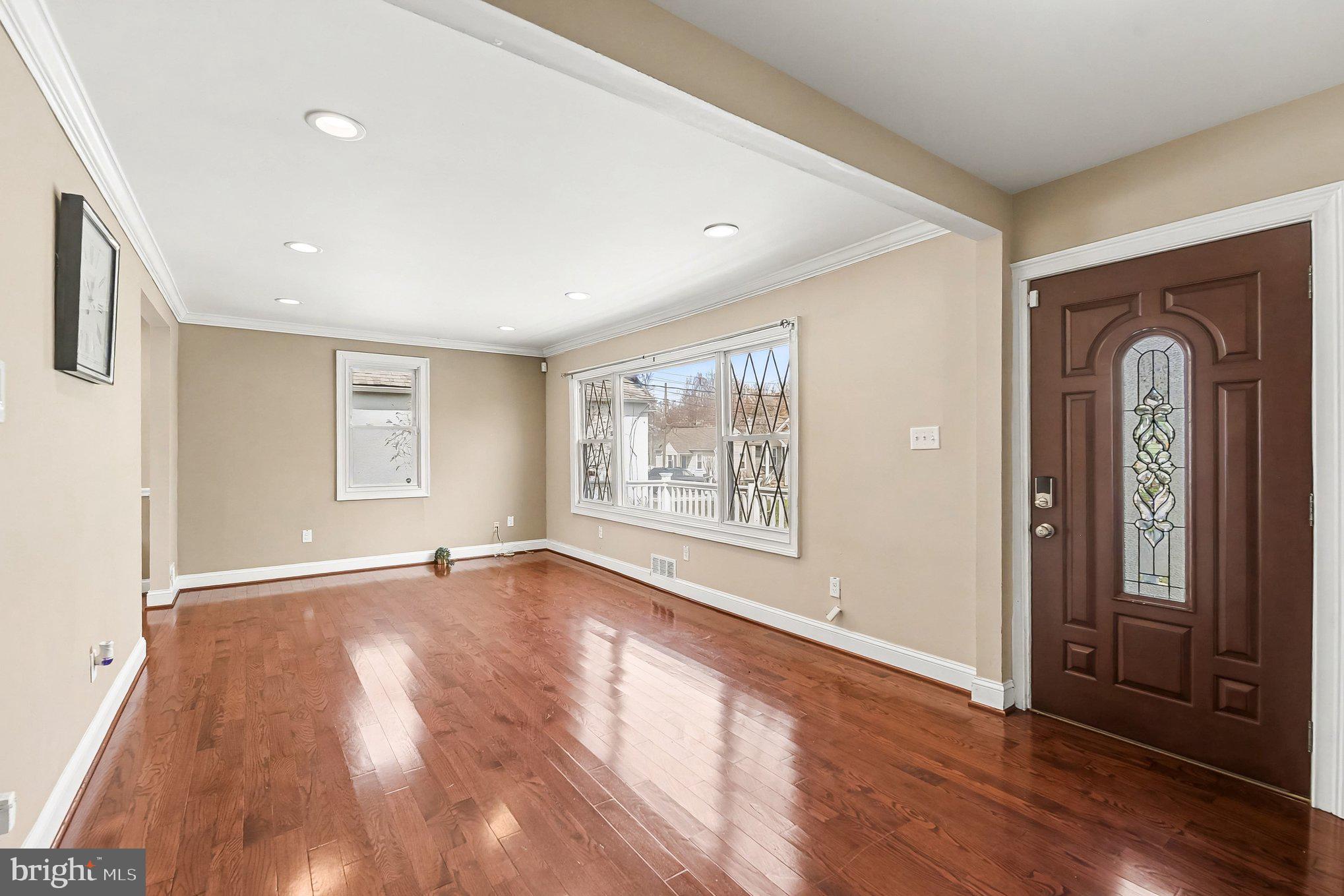 8716 Eddington Road Parkville, MD 21234 - Photo 5 of 27 a view of an empty room with wooden floor and a window