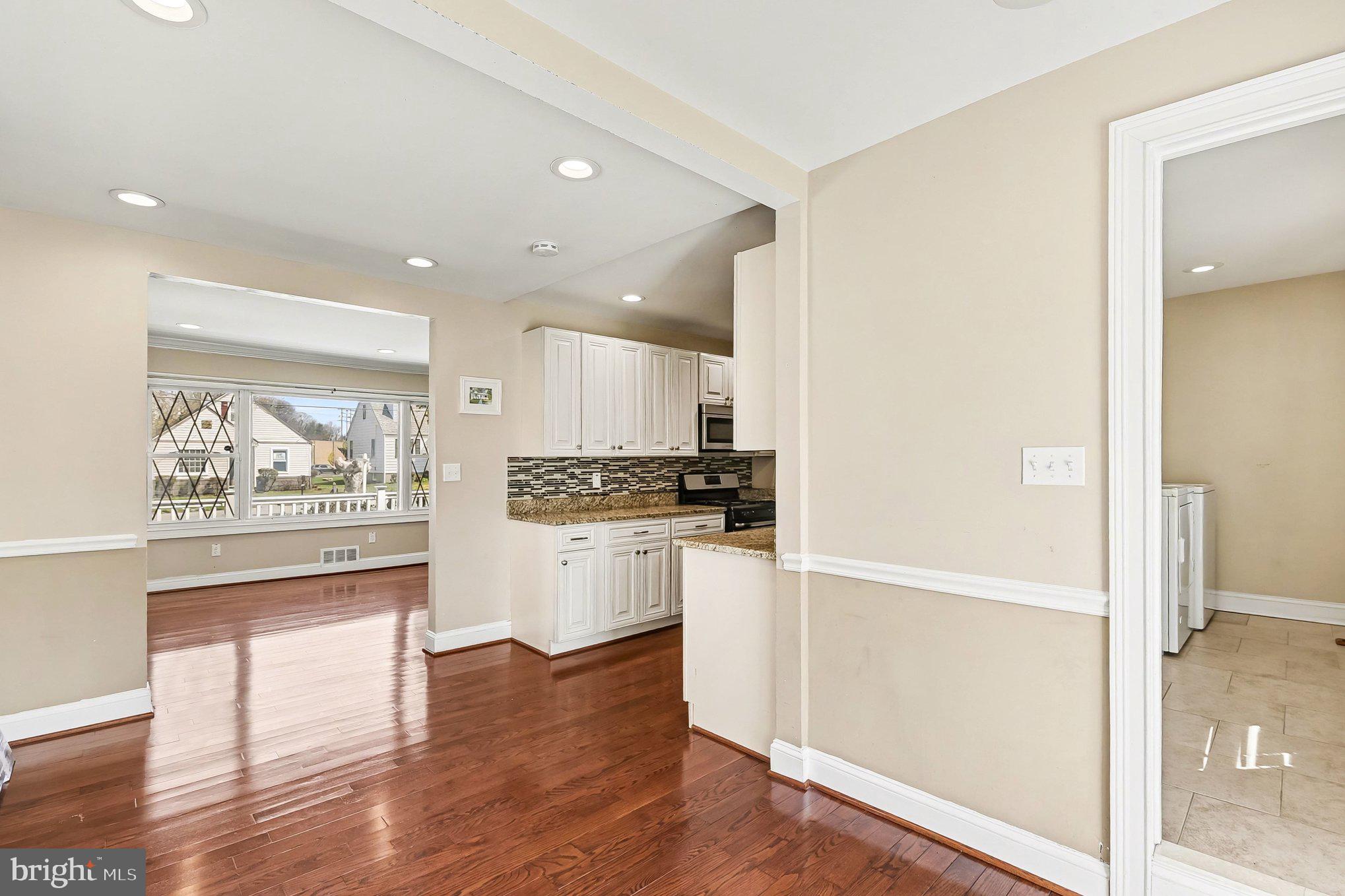 8716 Eddington Road Parkville, MD 21234 - Photo 6 of 27 a kitchen with a refrigerator and white cabinets