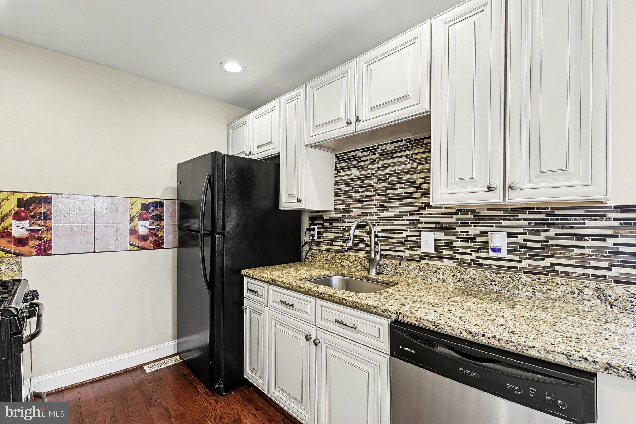 8716 Eddington Road Parkville, MD 21234 - Photo 7 of 27 a kitchen with stainless steel appliances granite countertop a refrigerator sink and cabinets