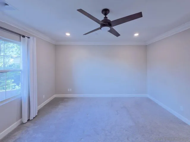 an empty room with a window and a fan