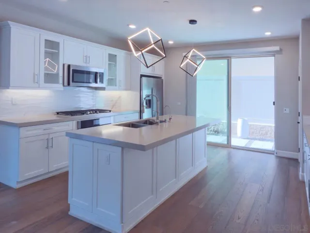 a kitchen with a sink cabinets and wooden floor