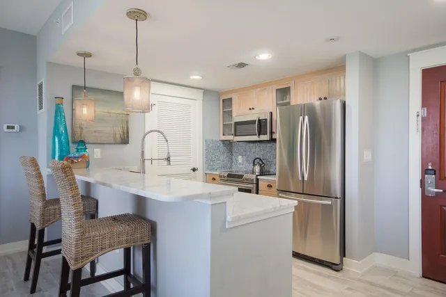 a kitchen with refrigerator and chairs