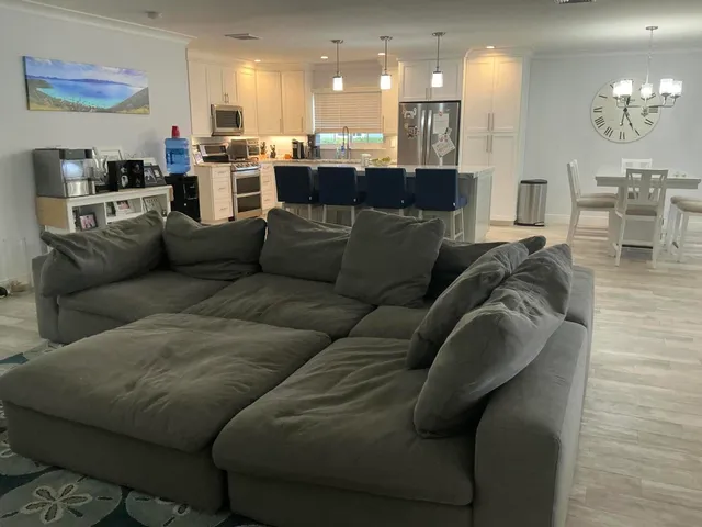 a living room with furniture kitchen and a chandelier