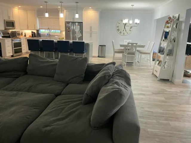 a living room with furniture and a dining table with kitchen view