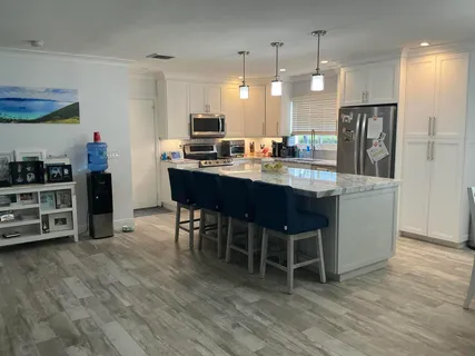 a kitchen with stainless steel appliances a dining table chairs and stove
