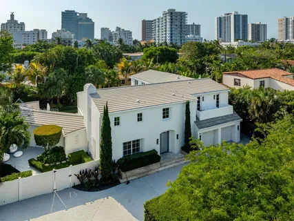 an aerial view of a house with a yard and large tree