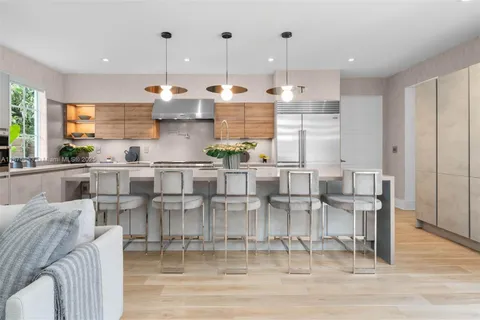 a kitchen with stainless steel appliances granite countertop a sink a stove and a refrigerator