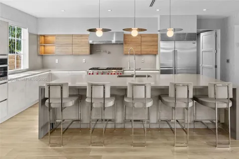 a kitchen with stainless steel appliances kitchen island granite countertop a table and chairs in it