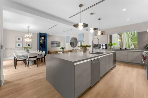 a large kitchen with kitchen island a large counter space a sink appliances and a large window