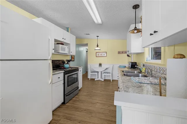 a kitchen with sink cabinets and wooden floor