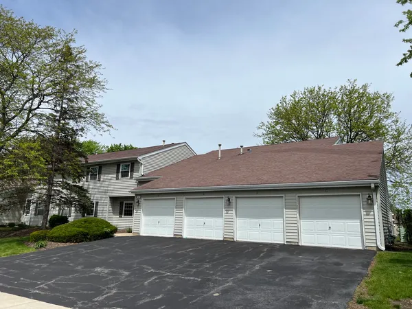 a front view of a house with a garden and garage