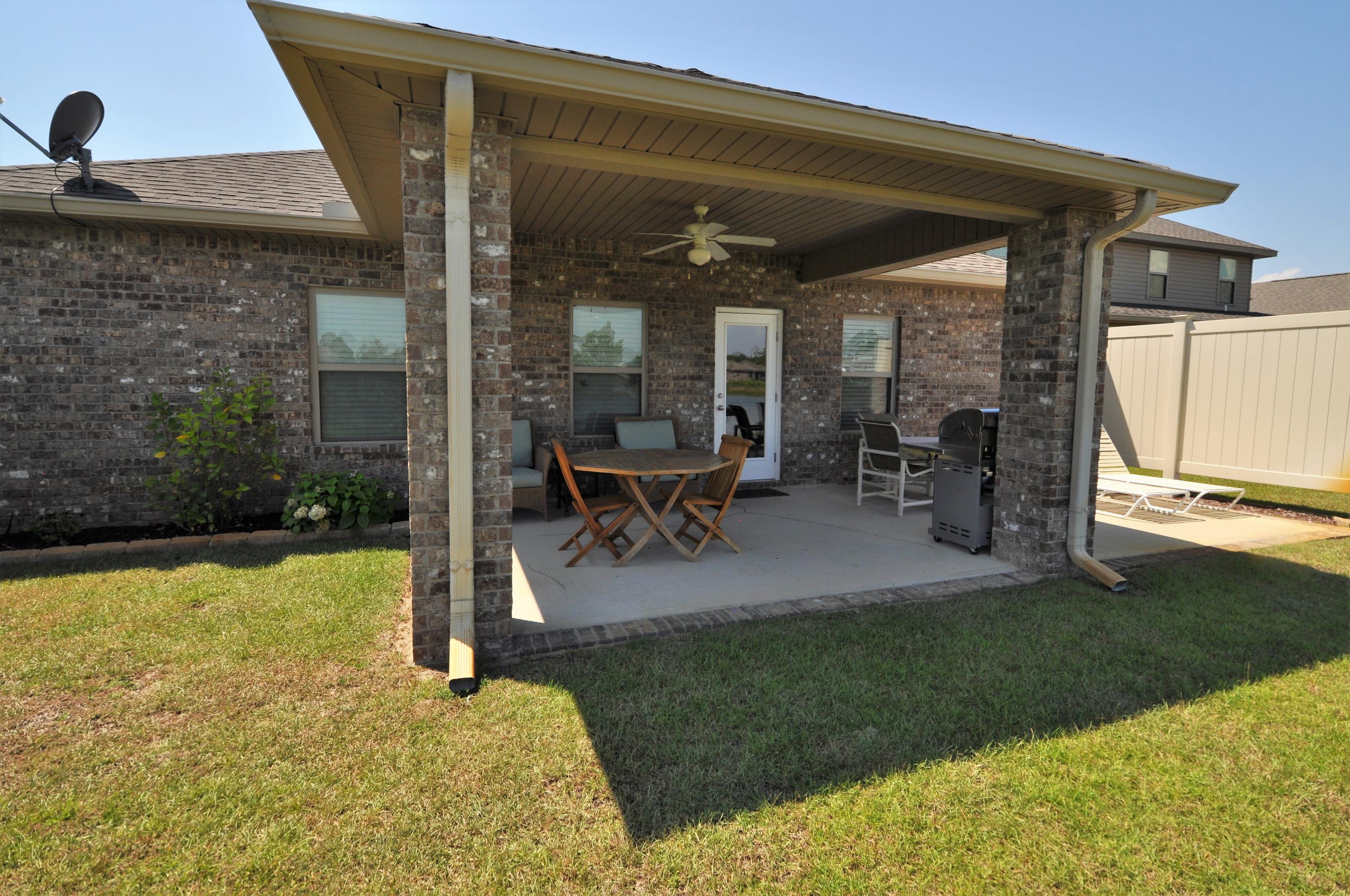 281 Pin Oak Loop Santa Rosa Beach, FL 32459 - Photo 21 of 21 a view of a patio with table and chairs under an umbrella