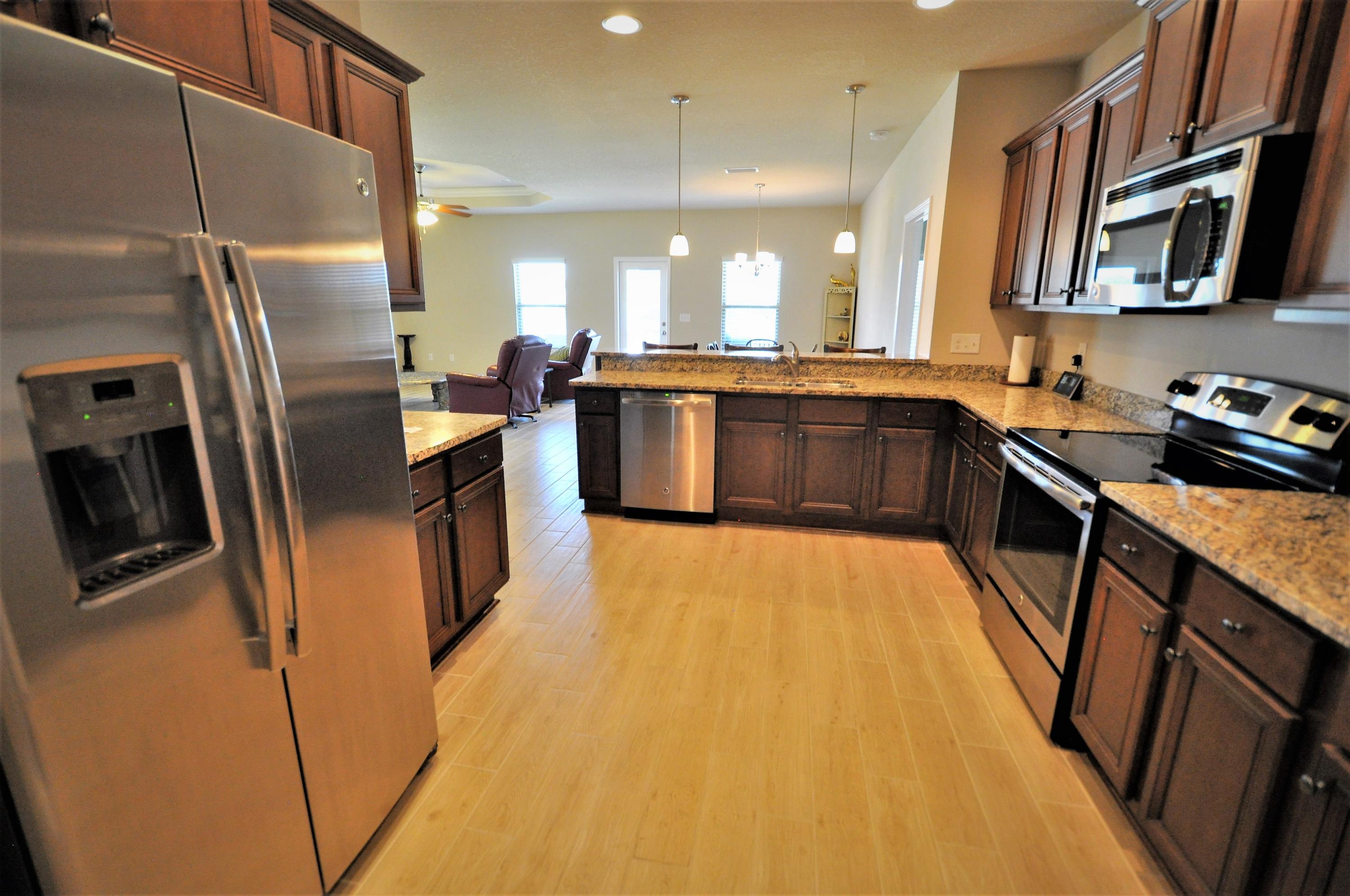 281 Pin Oak Loop Santa Rosa Beach, FL 32459 - Photo 5 of 21 a kitchen with stainless steel appliances granite countertop a refrigerator a stove a sink a washer dryer and a refrigerator