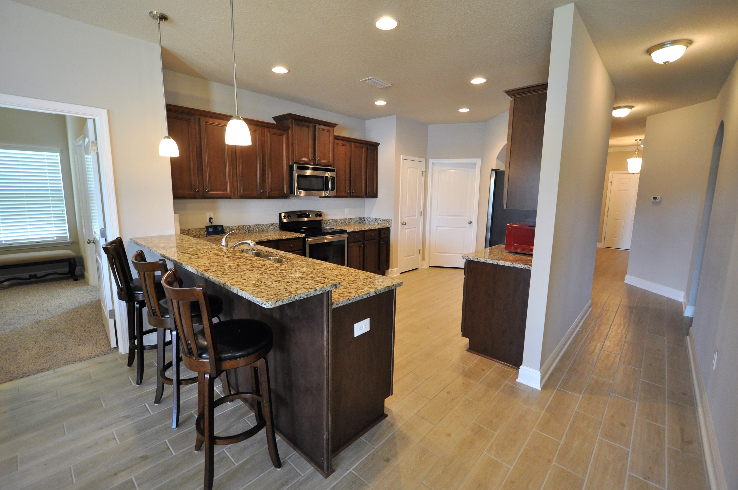 281 Pin Oak Loop Santa Rosa Beach, FL 32459 - Photo 6 of 21 a kitchen with kitchen island granite countertop wooden cabinets and stainless steel appliances