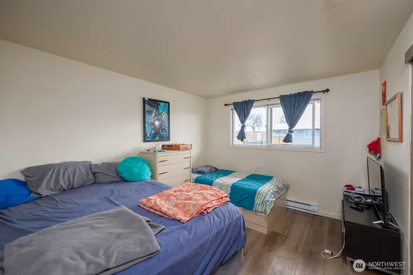 a bedroom with two beds and wooden floor