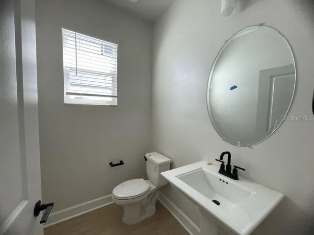 a bathroom with a toilet sink and mirror