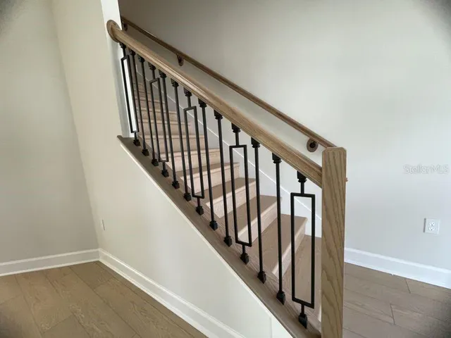 a view of staircase with railing and white walls