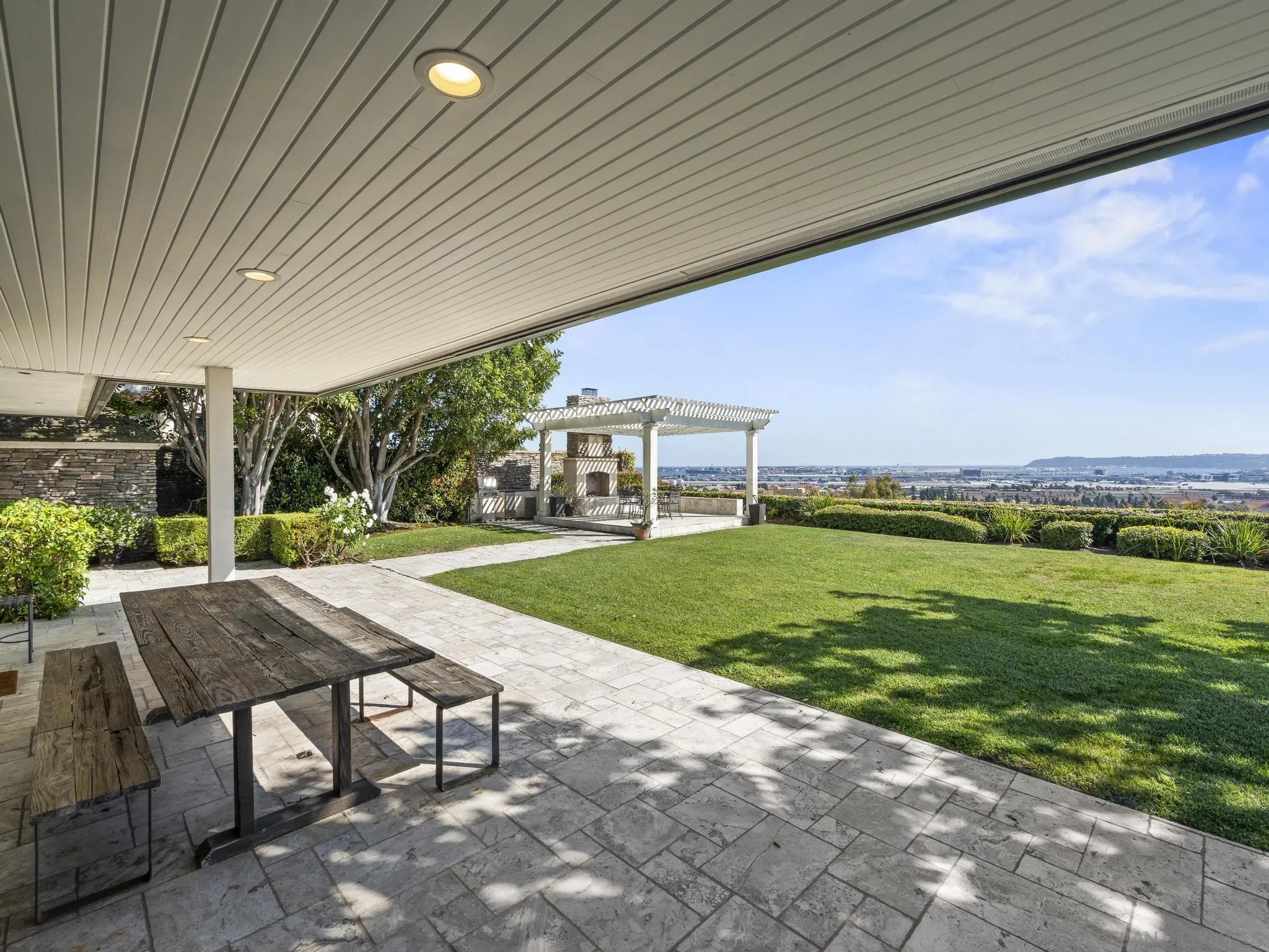 2323 San Juan Road San Diego, CA 92103 - Photo 21 of 47 a view of a patio with a table and chairs under an umbrella