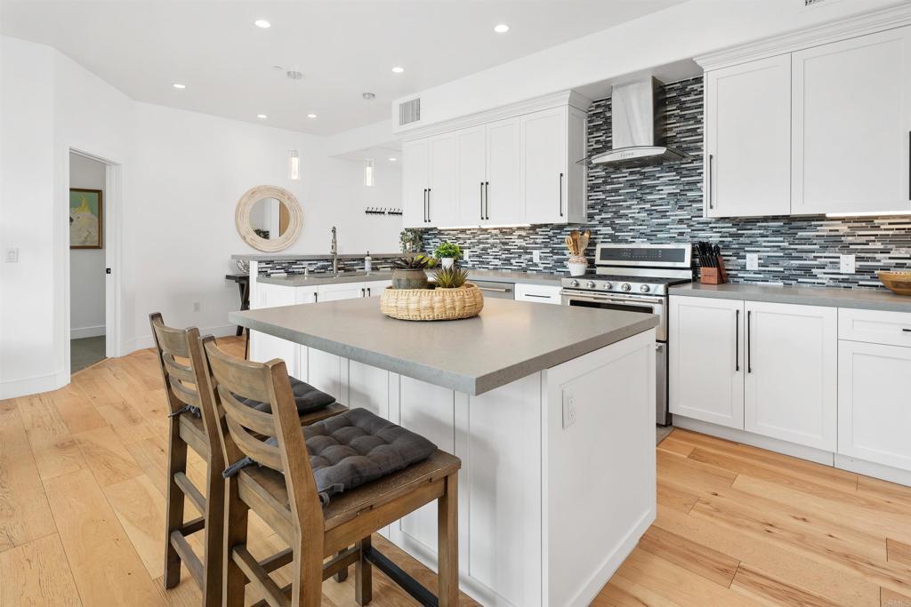 5656 La Jolla Boulevard, Unit 3 La Jolla, CA 92037 - Photo 13 of 35 a kitchen with stainless steel appliances kitchen island granite countertop a table chairs sink and cabinets