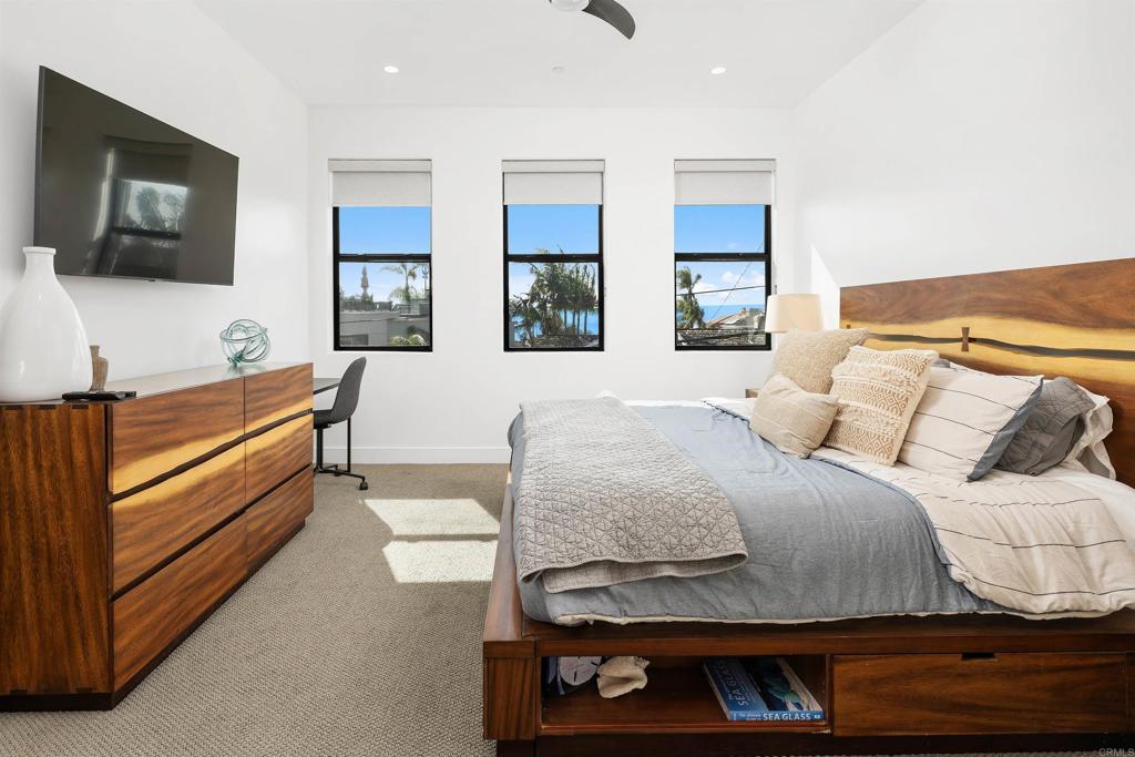 5656 La Jolla Boulevard, Unit 3 La Jolla, CA 92037 - Photo 16 of 35 a bedroom with a bed and flat screen tv