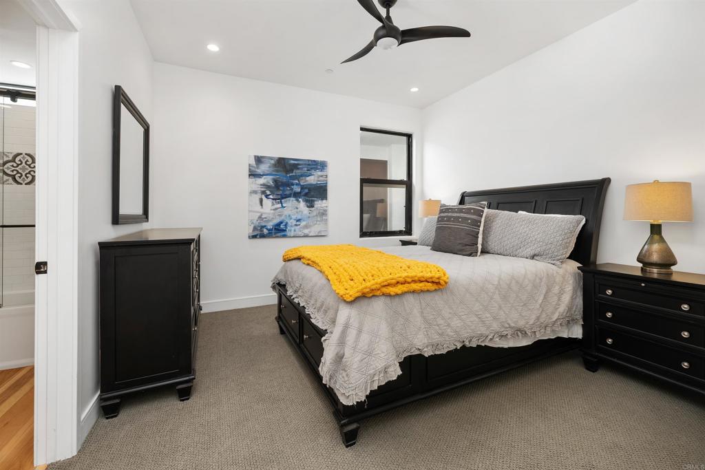 5656 La Jolla Boulevard, Unit 3 La Jolla, CA 92037 - Photo 21 of 35 a spacious bedroom with a bed and a lamp