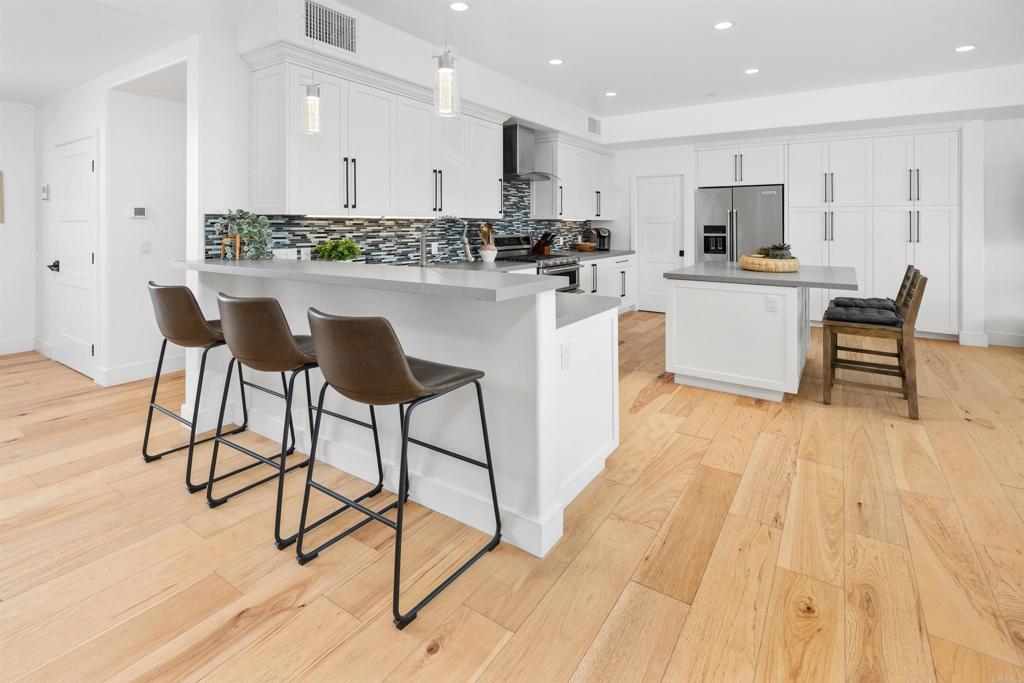 5656 La Jolla Boulevard, Unit 3 La Jolla, CA 92037 - Photo 6 of 35 a kitchen with stainless steel appliances kitchen island granite countertop a stove a sink and a refrigerator