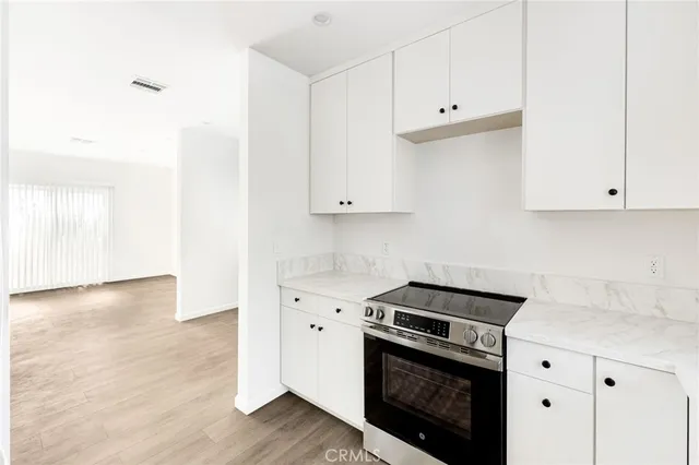 a kitchen with granite countertop white cabinets and white appliances