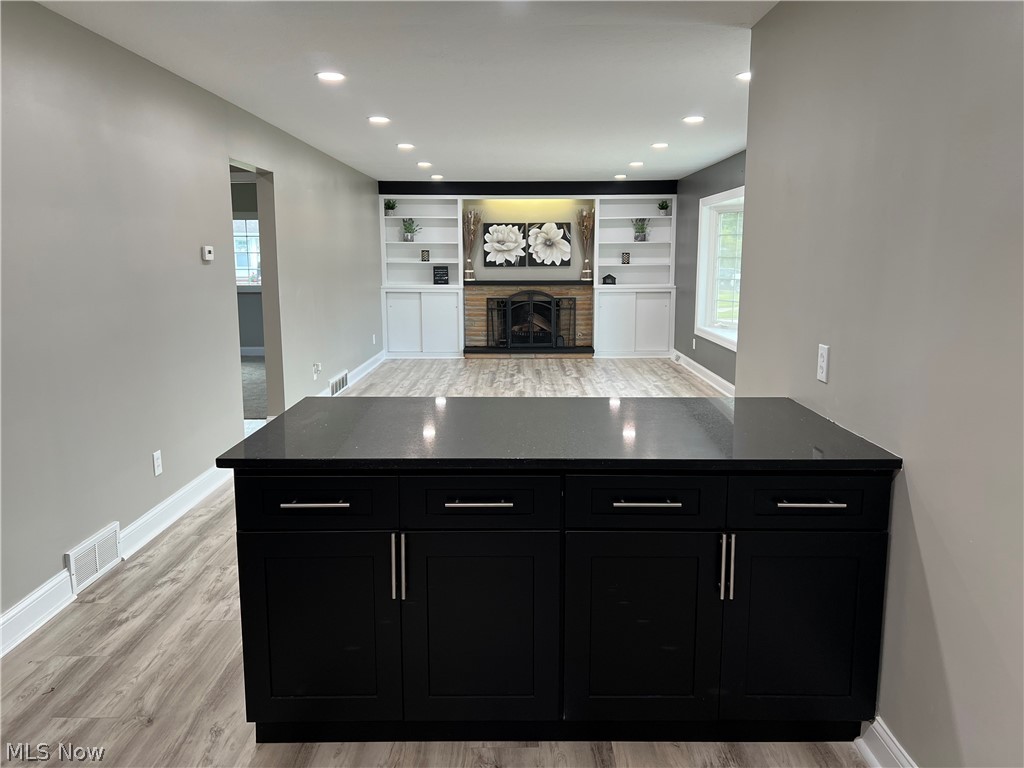 7475 Selwick Drive Parma, OH 44129 - Photo 5 of 29 Kitchen with light hardwood / wood-style flooring, a fireplace, built in shelves, and kitchen peninsula