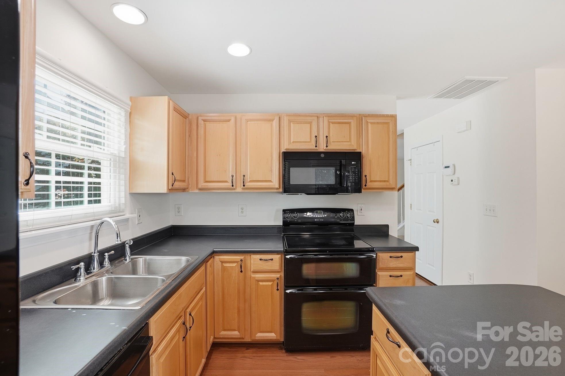 322 Deep Water Lane Fort Mill, SC 29715 - Photo 13 of 29 a kitchen with stainless steel appliances granite countertop a stove a sink and a microwave