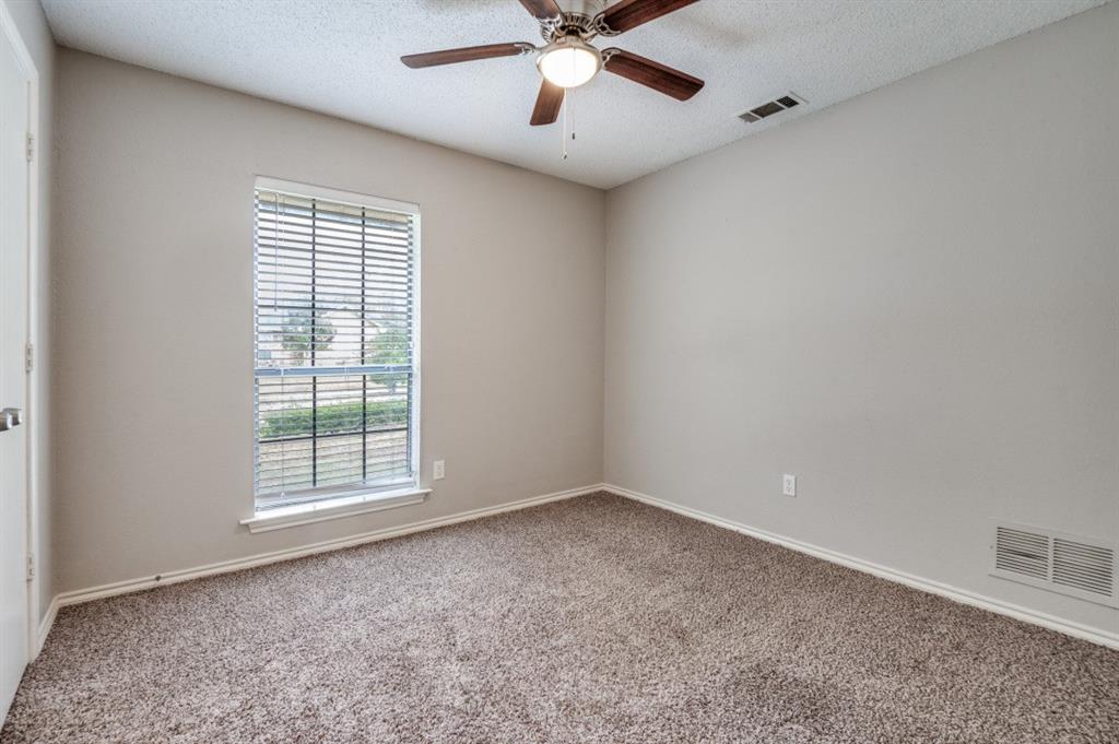 2118 Falcon Ridge Drive Carrollton, TX 75010 - Photo 12 of 18 an empty room with chandelier fan and windows