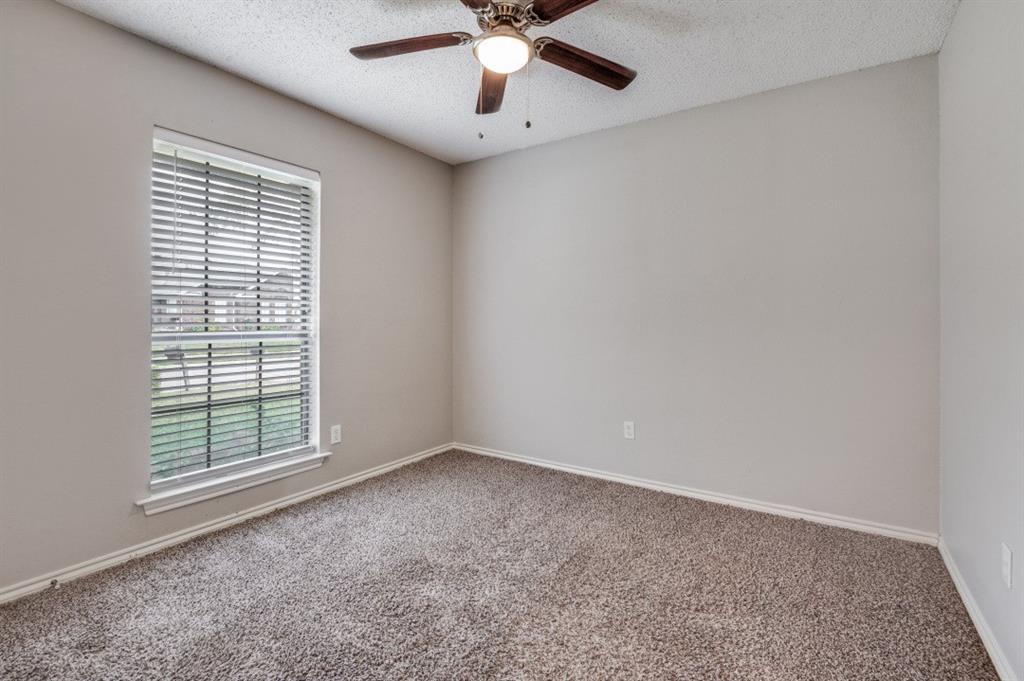 2118 Falcon Ridge Drive Carrollton, TX 75010 - Photo 13 of 18 an empty room with chandelier fan and windows