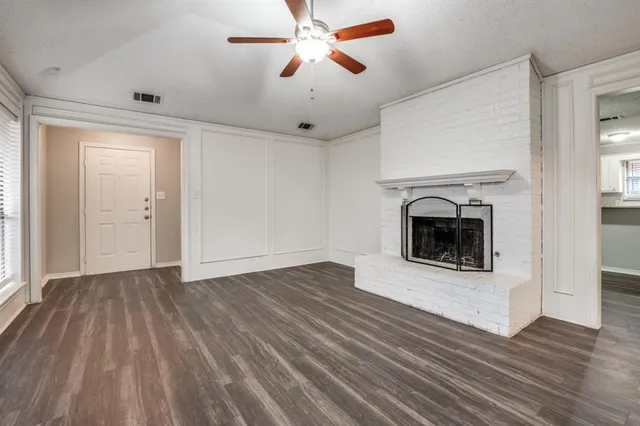 an empty room with wooden floor a fireplace