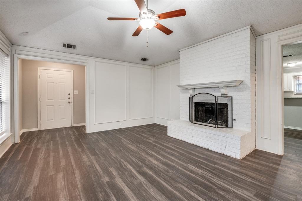 2118 Falcon Ridge Drive Carrollton, TX 75010 - Photo 2 of 18 an empty room with wooden floor a fireplace