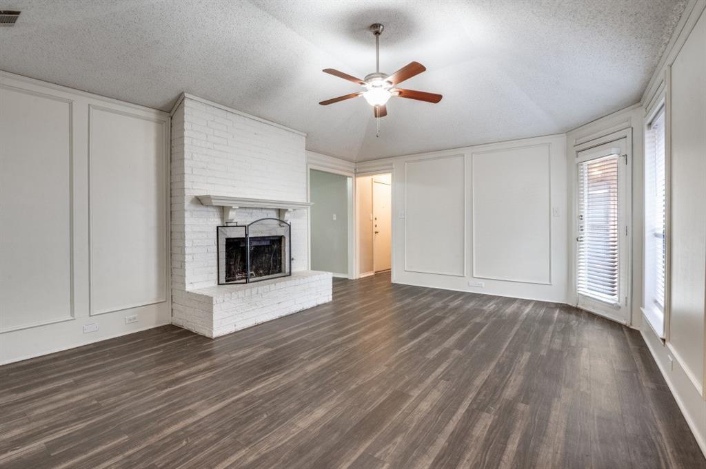2118 Falcon Ridge Drive Carrollton, TX 75010 - Photo 4 of 18 a view of an empty room with wooden floor fireplace and a window