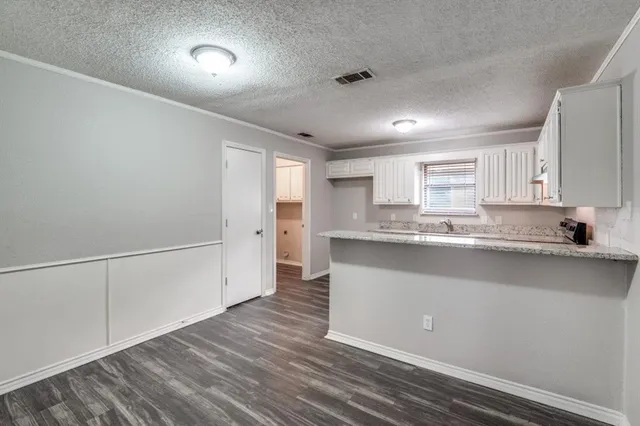 a kitchen with granite countertop a sink and cabinets